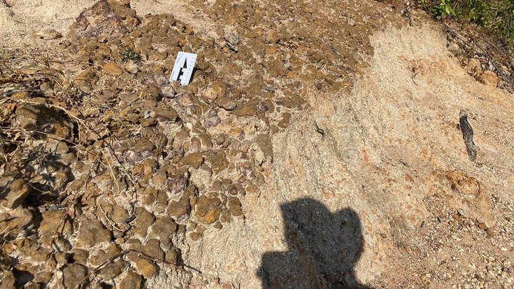 Zusammengebackene Trümmer vom Einschlag | Bildquelle: Kerry Sieh Krater in einer Erdschicht, im Vordergrund ein Schatten der fotografierenden Person