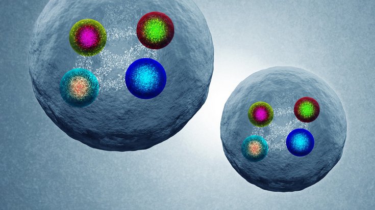 Künstlerische Darstellung von Tetraquarks | Bildquelle: Daniel Dominguez/CERN Auf der Grafik sind zwei Kugeln zu erkennen, in denen sich jeweils vier weitere unterschiedlich gefärbte kleinere Kugeln befinden.